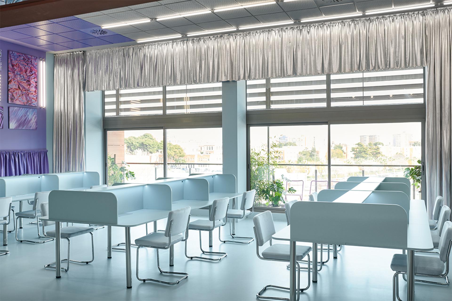 Bright and airy coworking space in Valencia featuring minimalist desks, modern decor, and large windows for natural light.