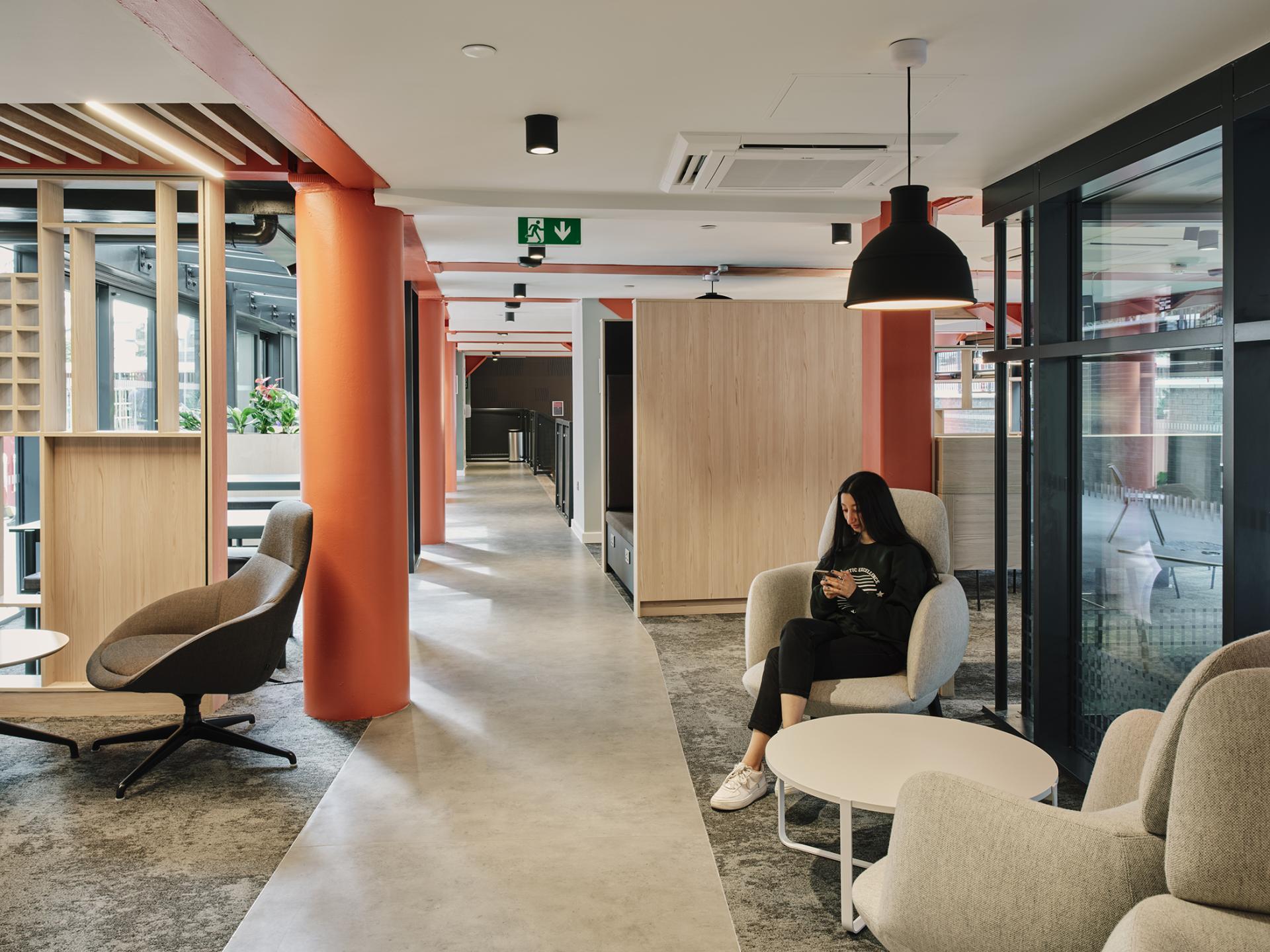 Modern interior of The Refinery student accommodation in Leeds, featuring stylish seating and student relaxing in a contemporary space.