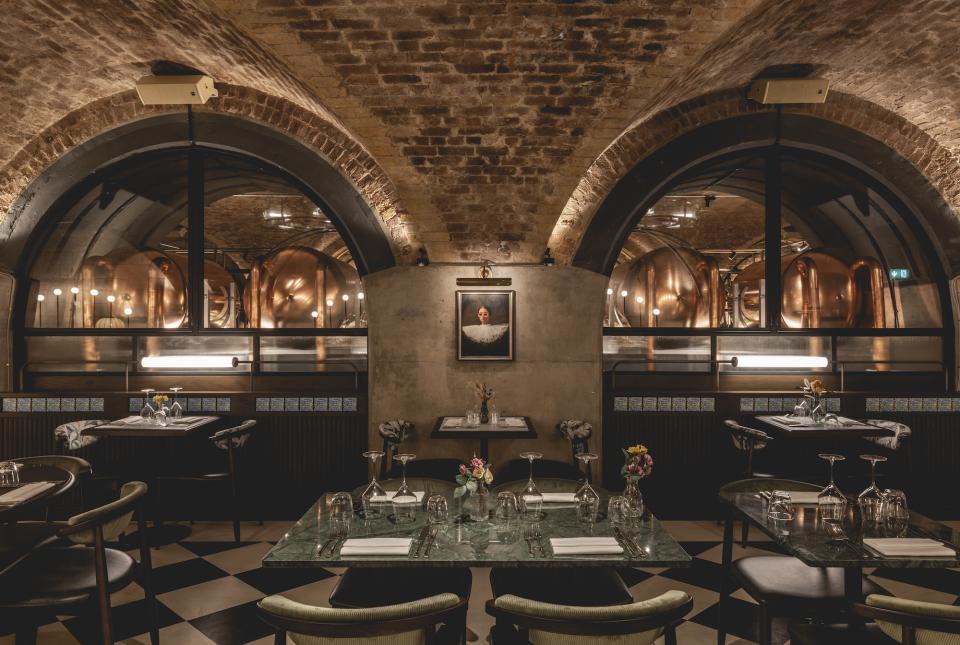Elegant dining setup at The Libertine, featuring exposed brick arches and stylish decor in London's Royal Exchange.