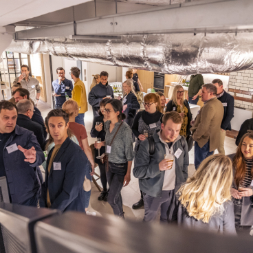 Networking event at Material Source Studio Manchester, featuring diverse attendees engaging in conversation and enjoying refreshments.