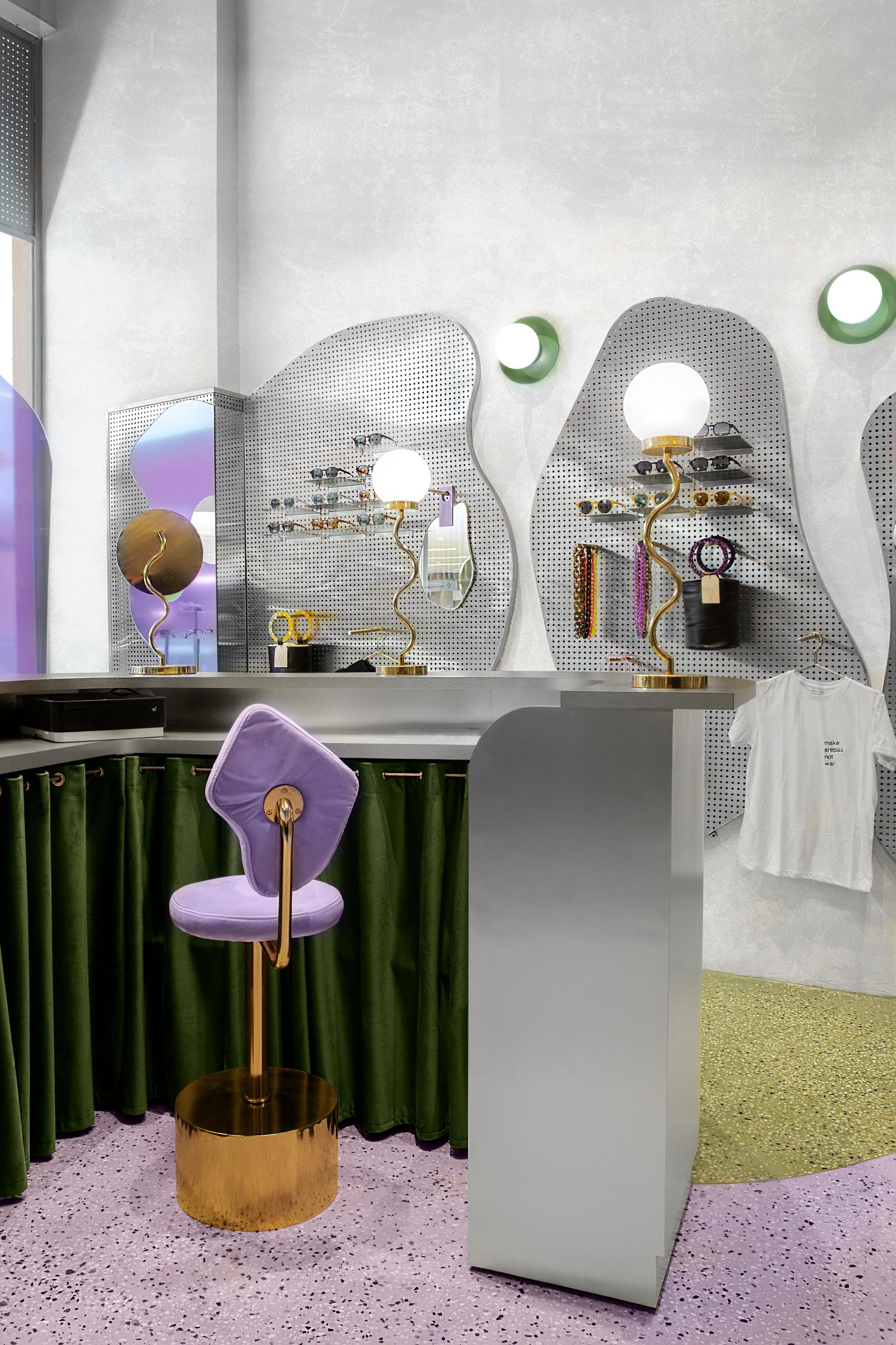 Modern retail space designed by Masquespacio for Breathe, featuring colorful decor, display shelves for sunglasses, and elegant furnishings.