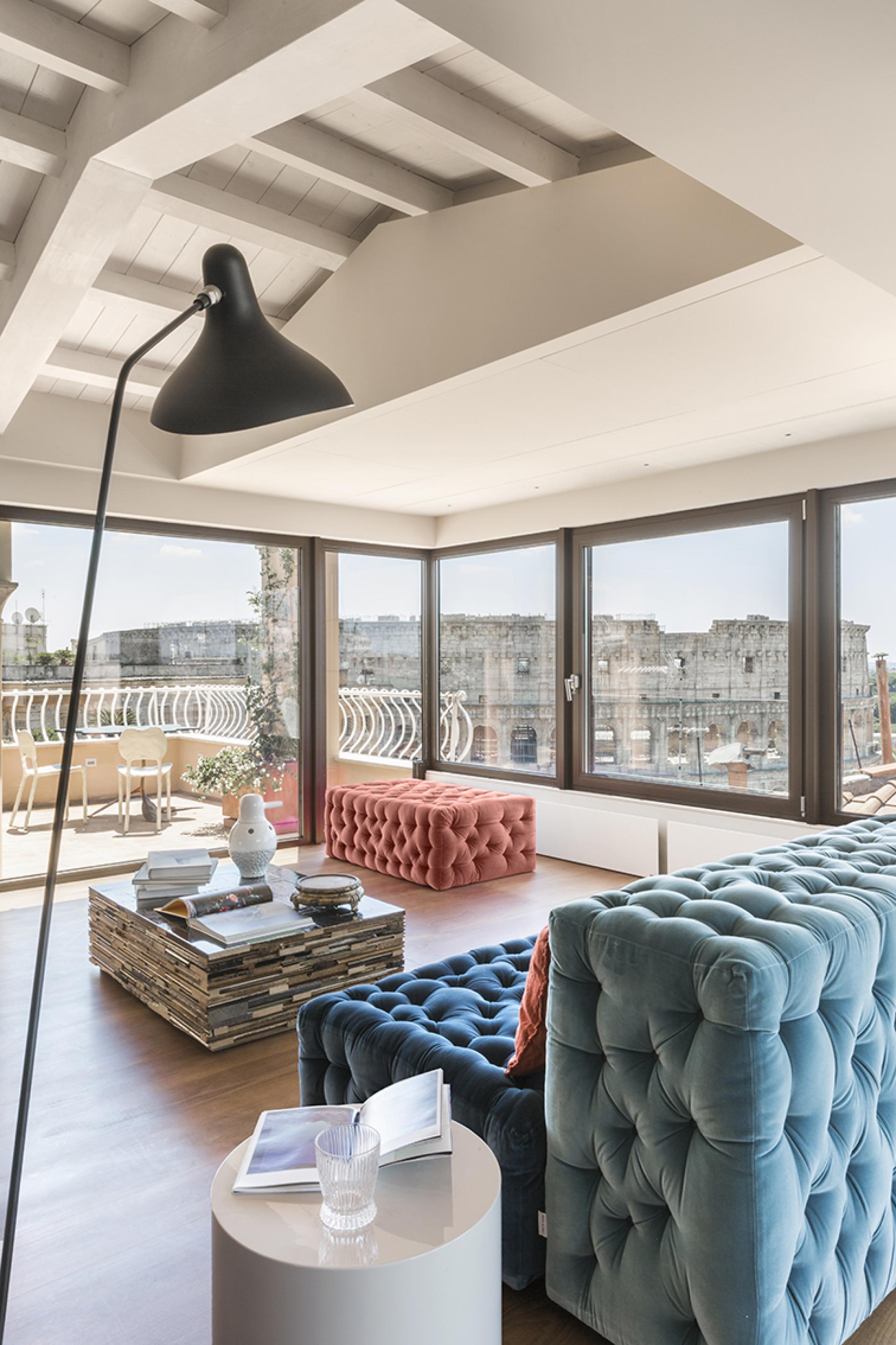 Spacious artist's loft featuring modern furniture and stunning views of the Colosseum from large windows.