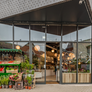 Exterior view of The Bristol Loaf featuring a fresh produce display and inviting atmosphere in a modern setting.