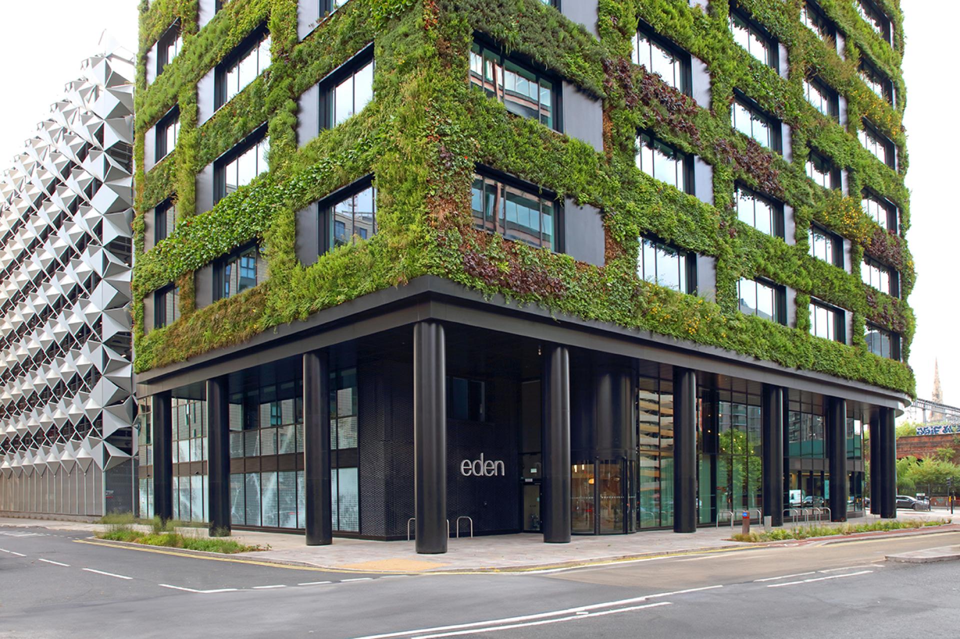 Sustainable building Eden, New Bailey features a vibrant green wall and modern architecture in Manchester.