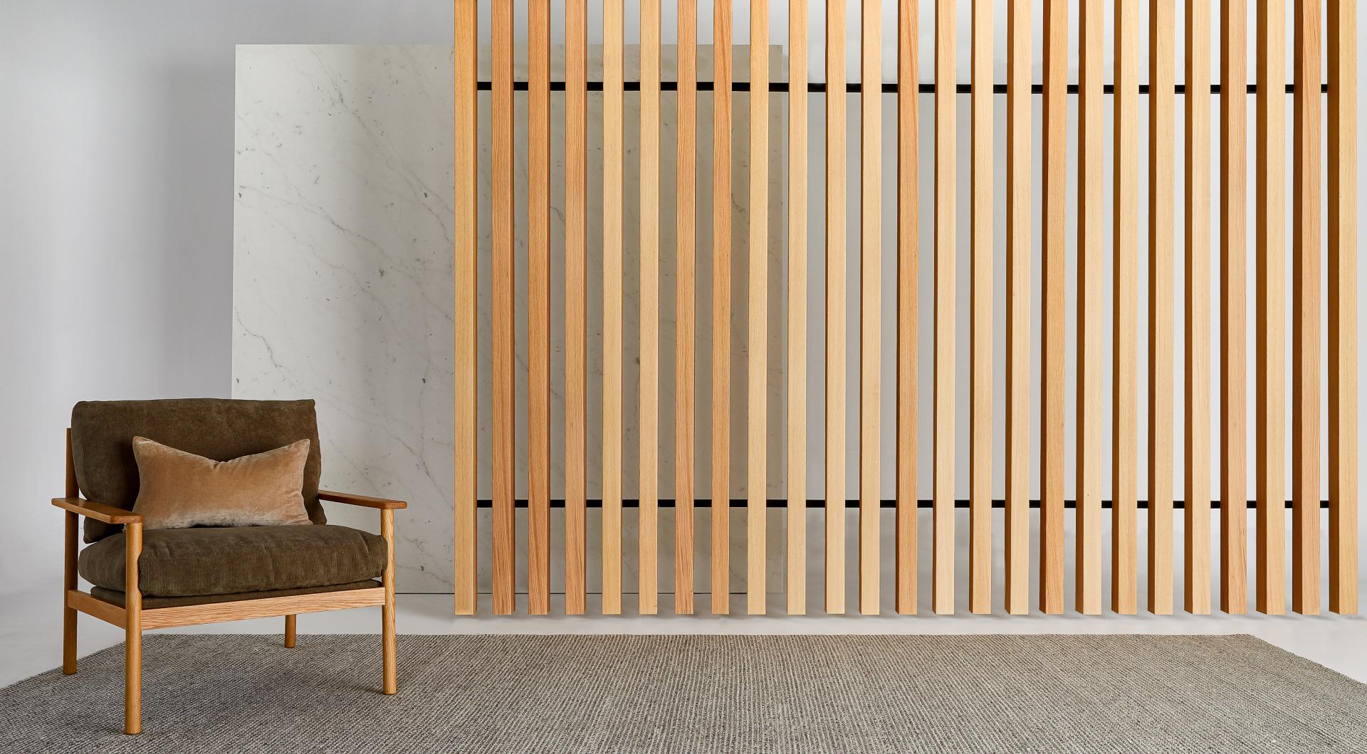 Luxurious living space showcasing acoustic timber features, a cozy chair, and a textured rug for modern interiors.