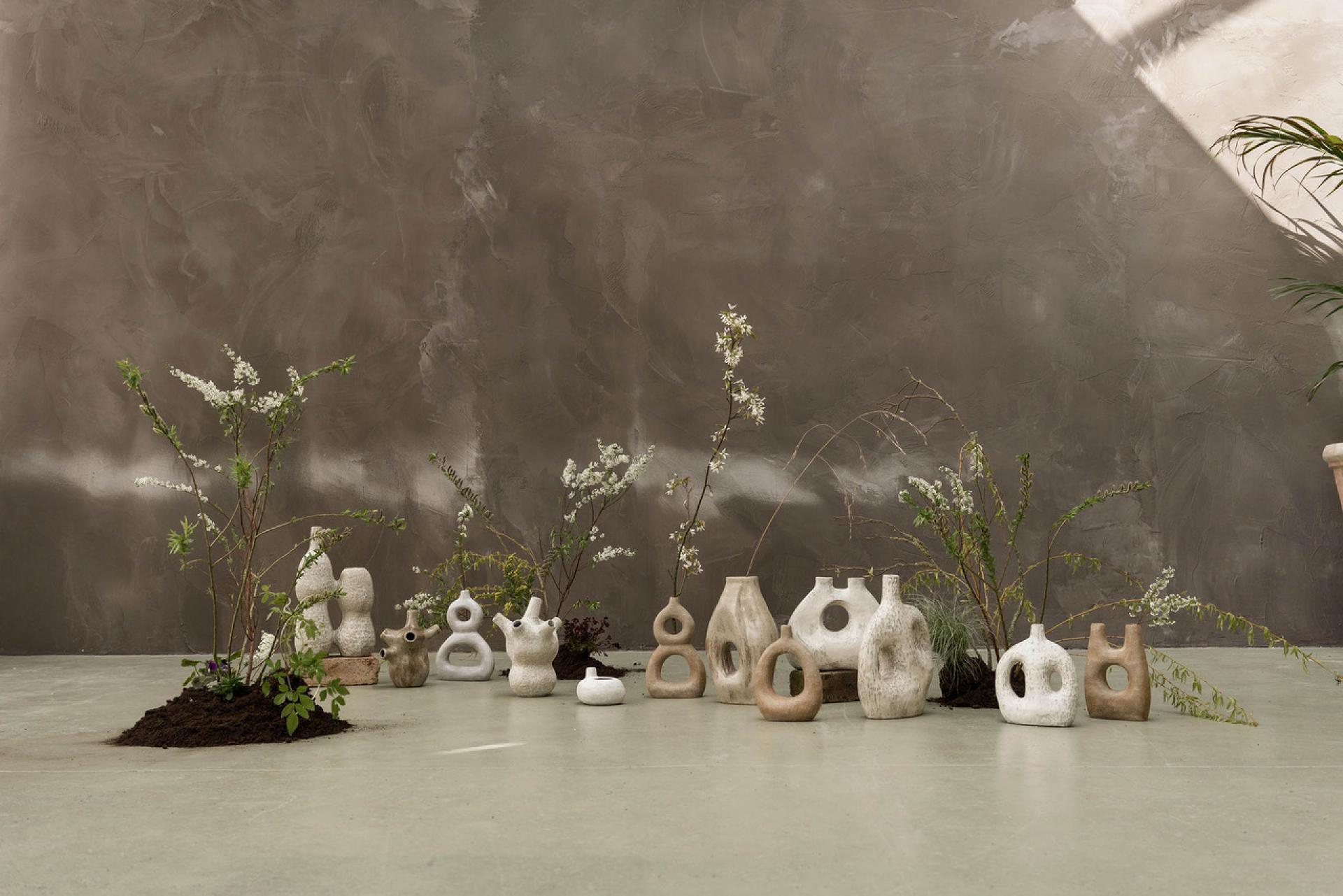 Handcrafted ceramic vases arranged with greenery against a textured wall, showcasing Glasgow's vibrant creative craft scene.