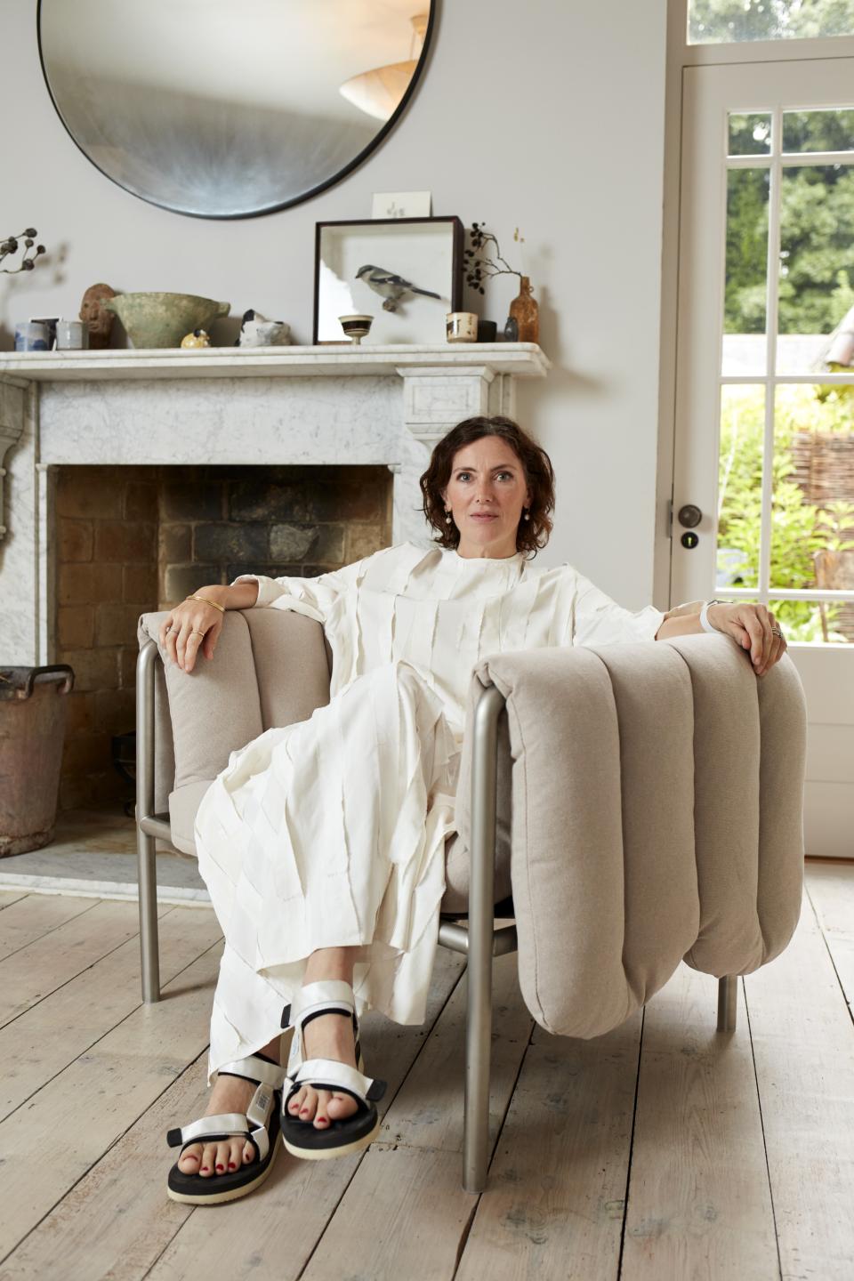 Stylish woman seated in the new Puffy Lounge Chair by Hem, showcasing modern design in a bright interior.
