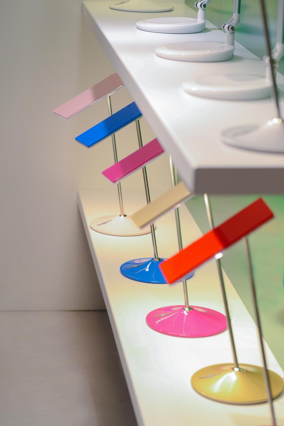 Colorful modern lamps displayed on a sleek shelf in Humanscale's new Manchester showroom, emphasizing innovative design.