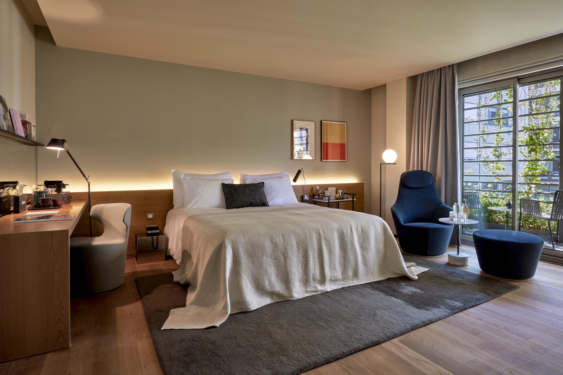 Stylish hotel room at Sir Victor Barcelona featuring modern decor, a cozy bed, and a balcony view.