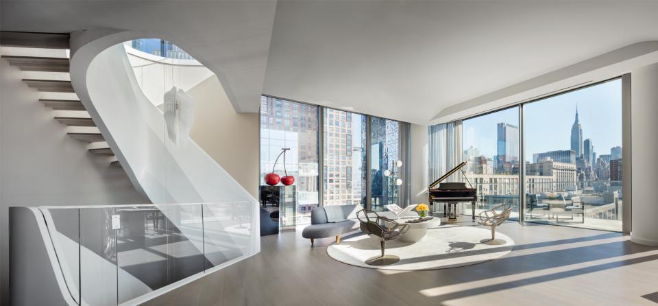 Luxurious triplex penthouse interior in West Chelsea featuring modern architecture, a grand piano, and iconic skyline views.