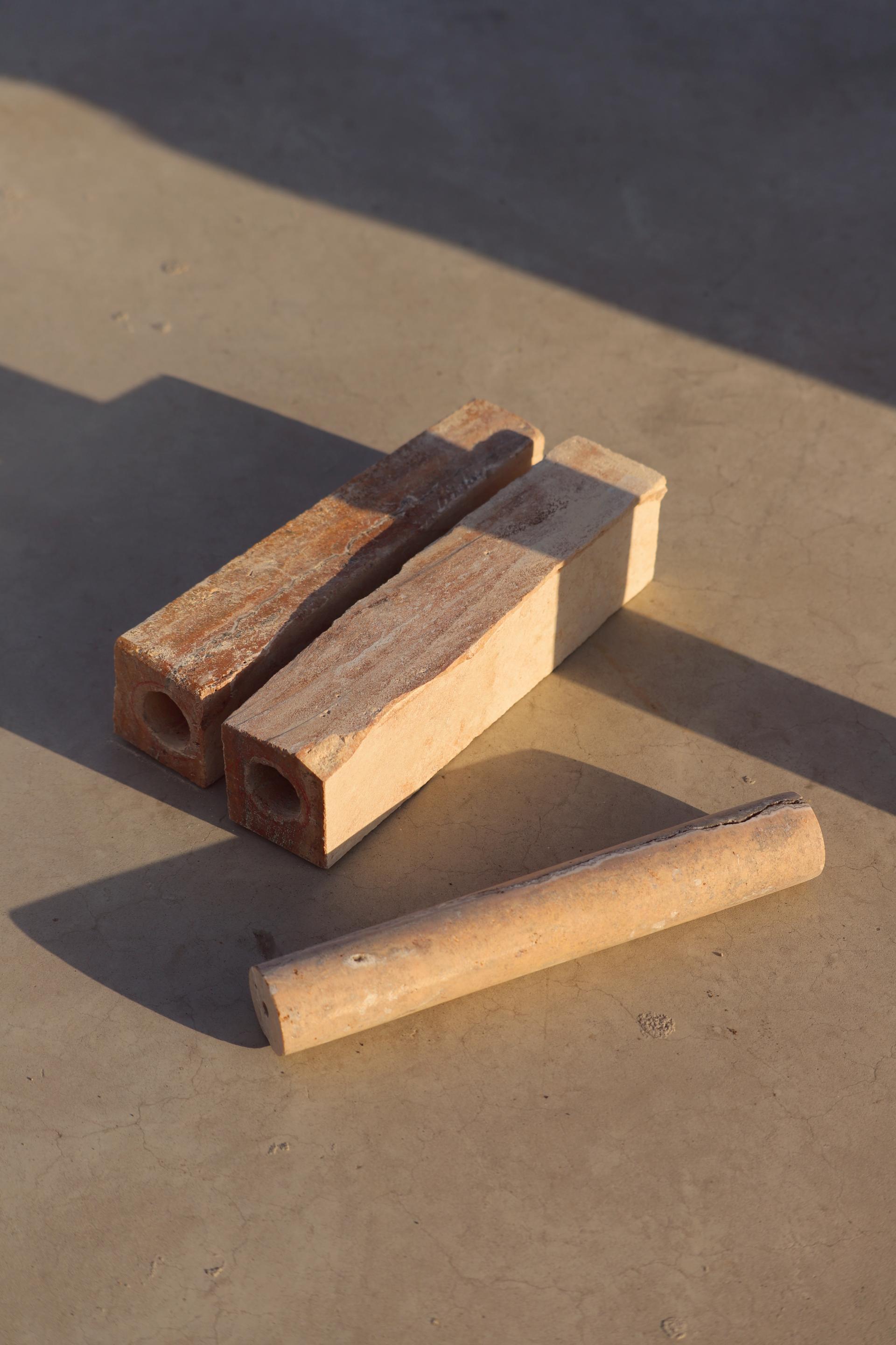 Natural stone pieces from the Meta collection, showcasing new finishes in white and ochre, on a textured surface.