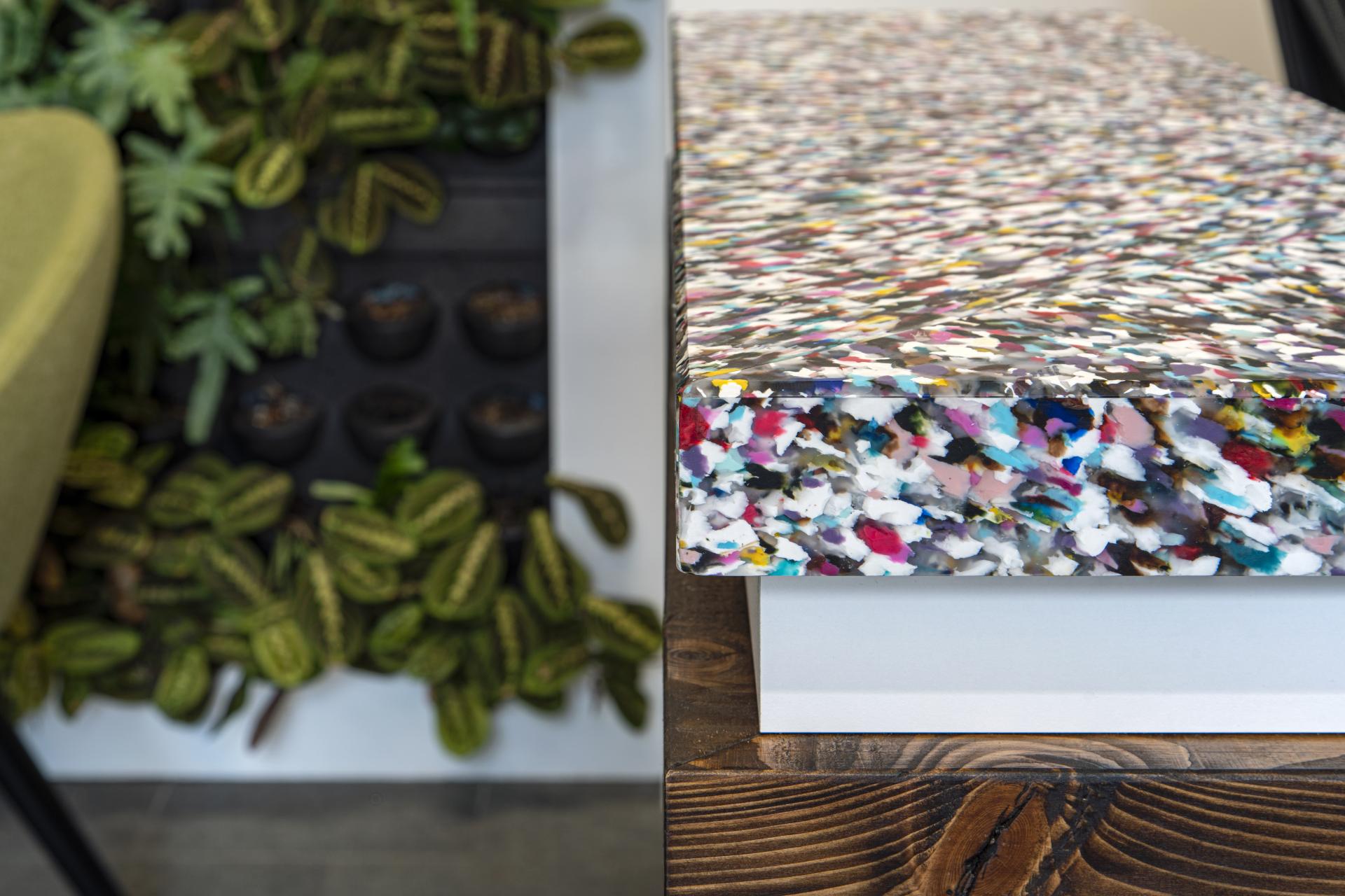 Vibrant desk surface designed with colorful materials, complemented by lush greenery, reflecting modern workplace aesthetics and data-driven design.