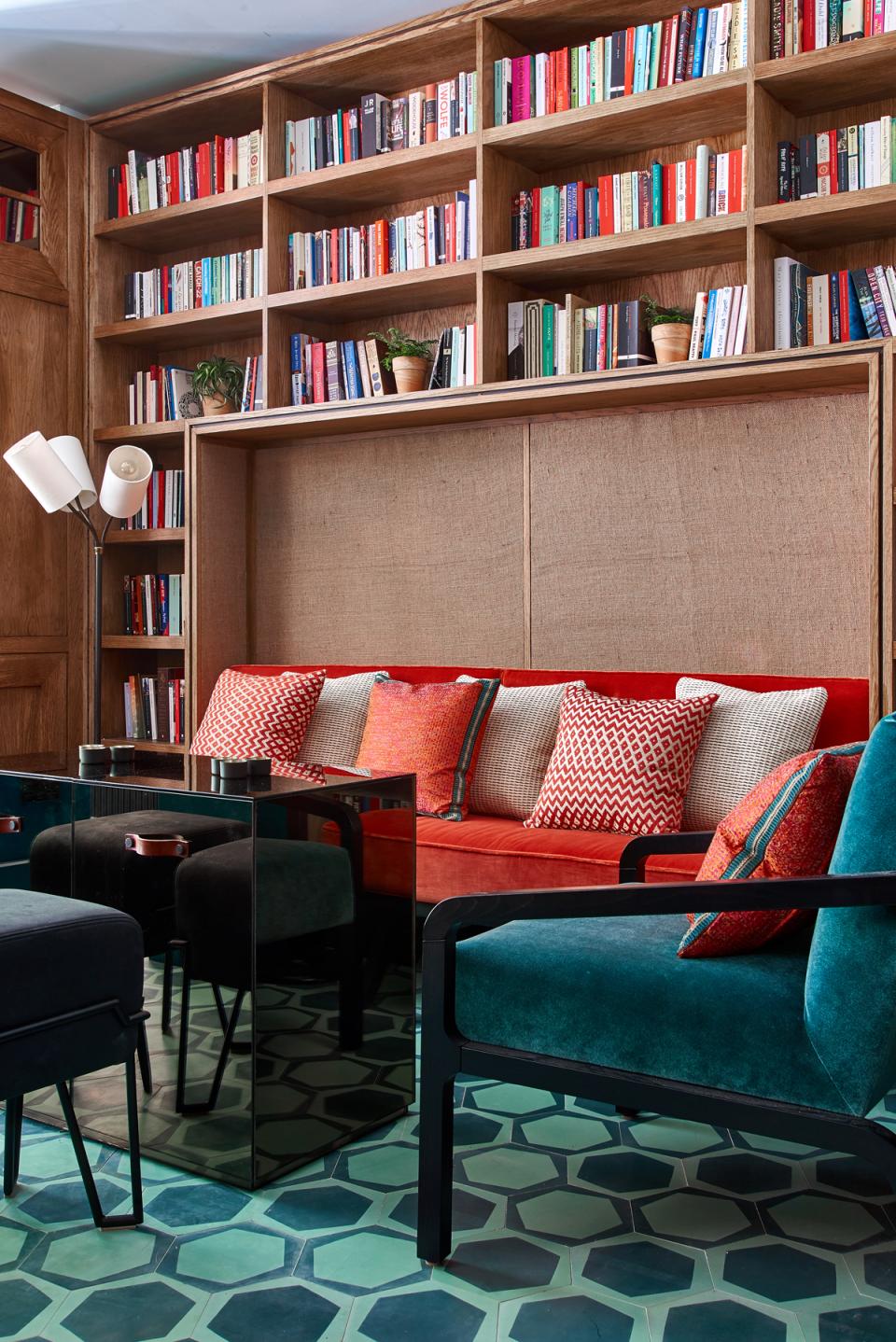 Stylish Art Deco interior of Teatulia's tea shop featuring vibrant seating, a patterned floor, and a book-filled shelf.