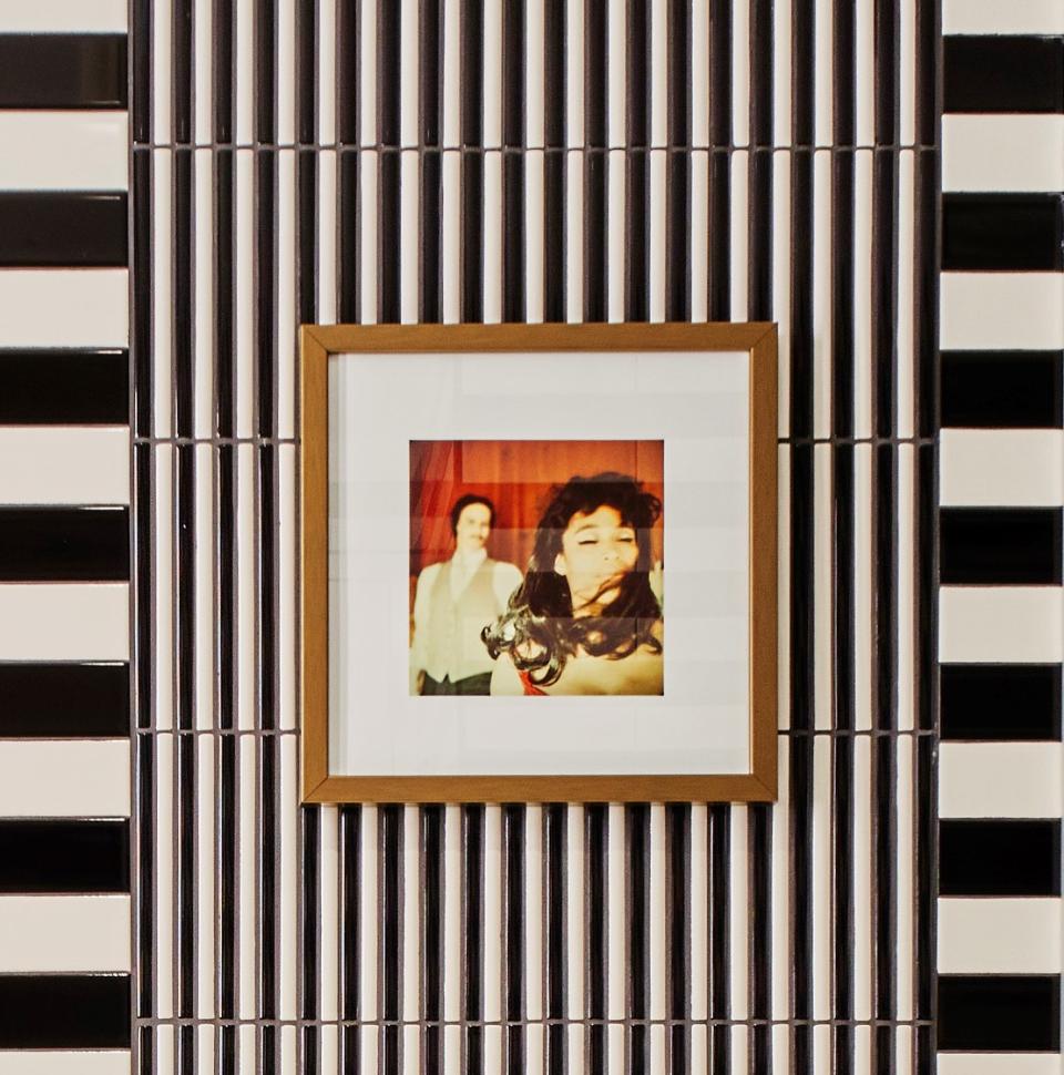 Framed vintage photograph featuring a woman with long hair against a stylish tiled wall, reflecting Yabu Pushelberg's design.