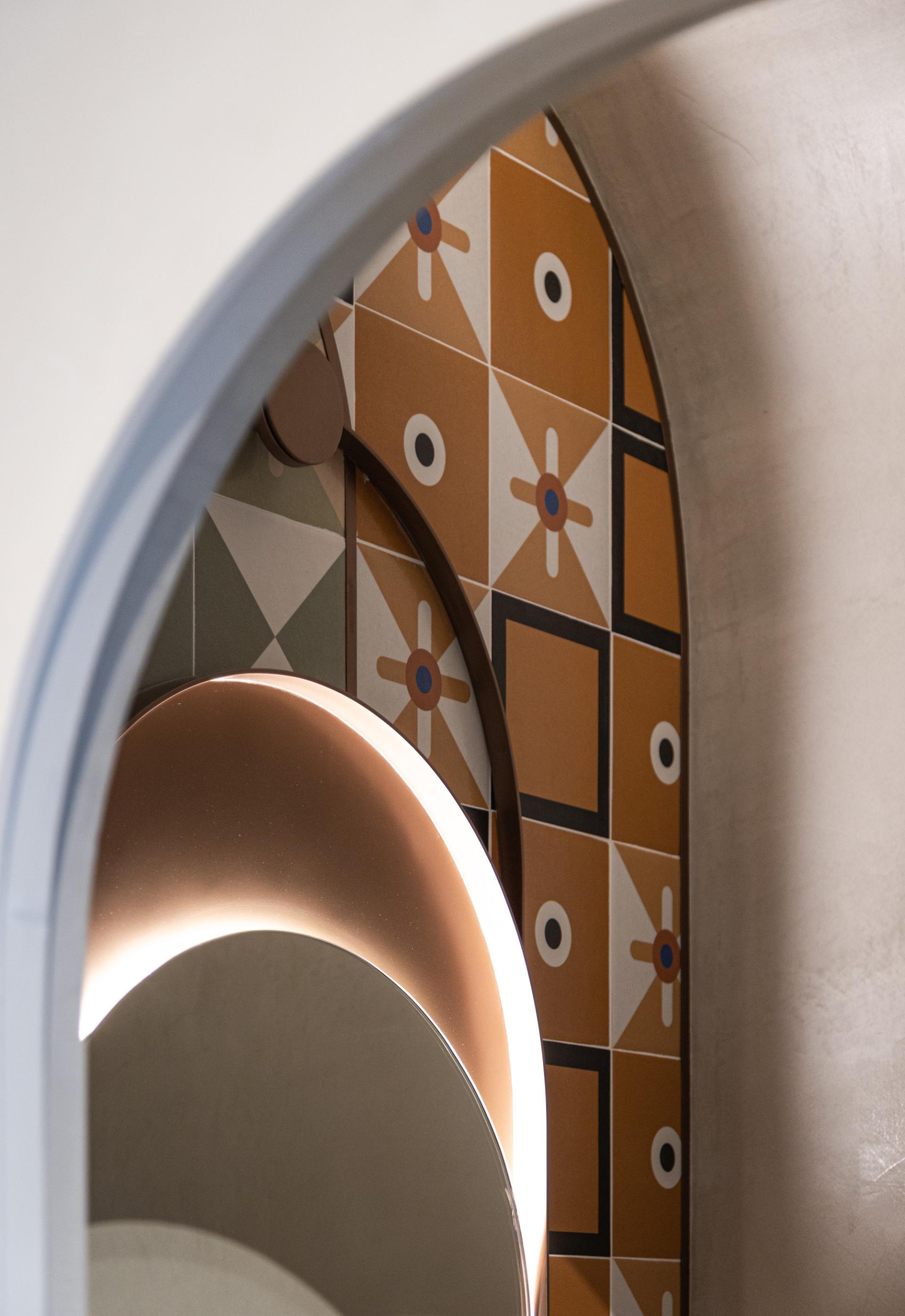 Vibrant Rajasthani-inspired wall design featuring geometric patterns and soft lighting in Jaipur Rugs’ Dubai showroom.