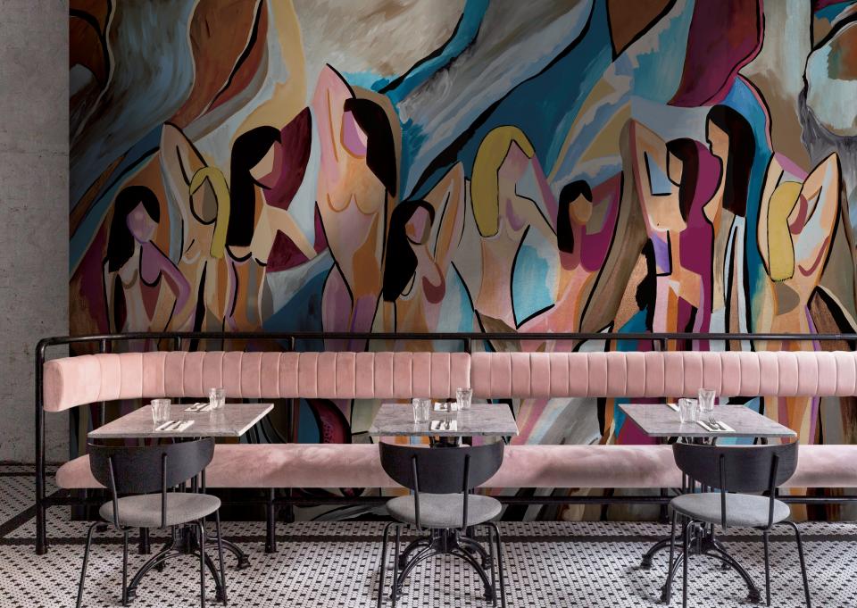 Vibrant mural featuring abstract figures, showcasing organic shapes and colors, enhancing the atmosphere of a modern dining space.