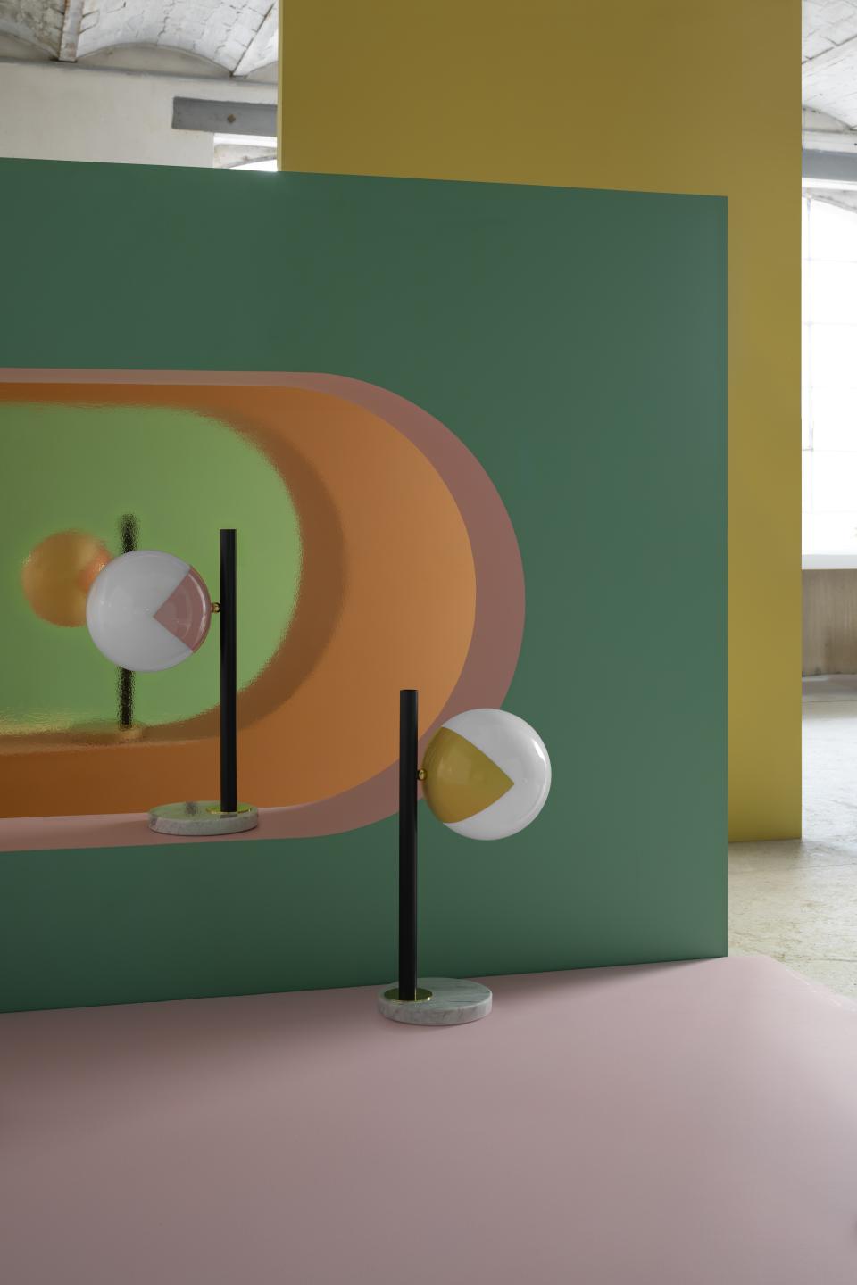 Colorful globe-shaped 'eyeball' lamps on sleek black stems, showcasing modern design in an artistic interior setting.