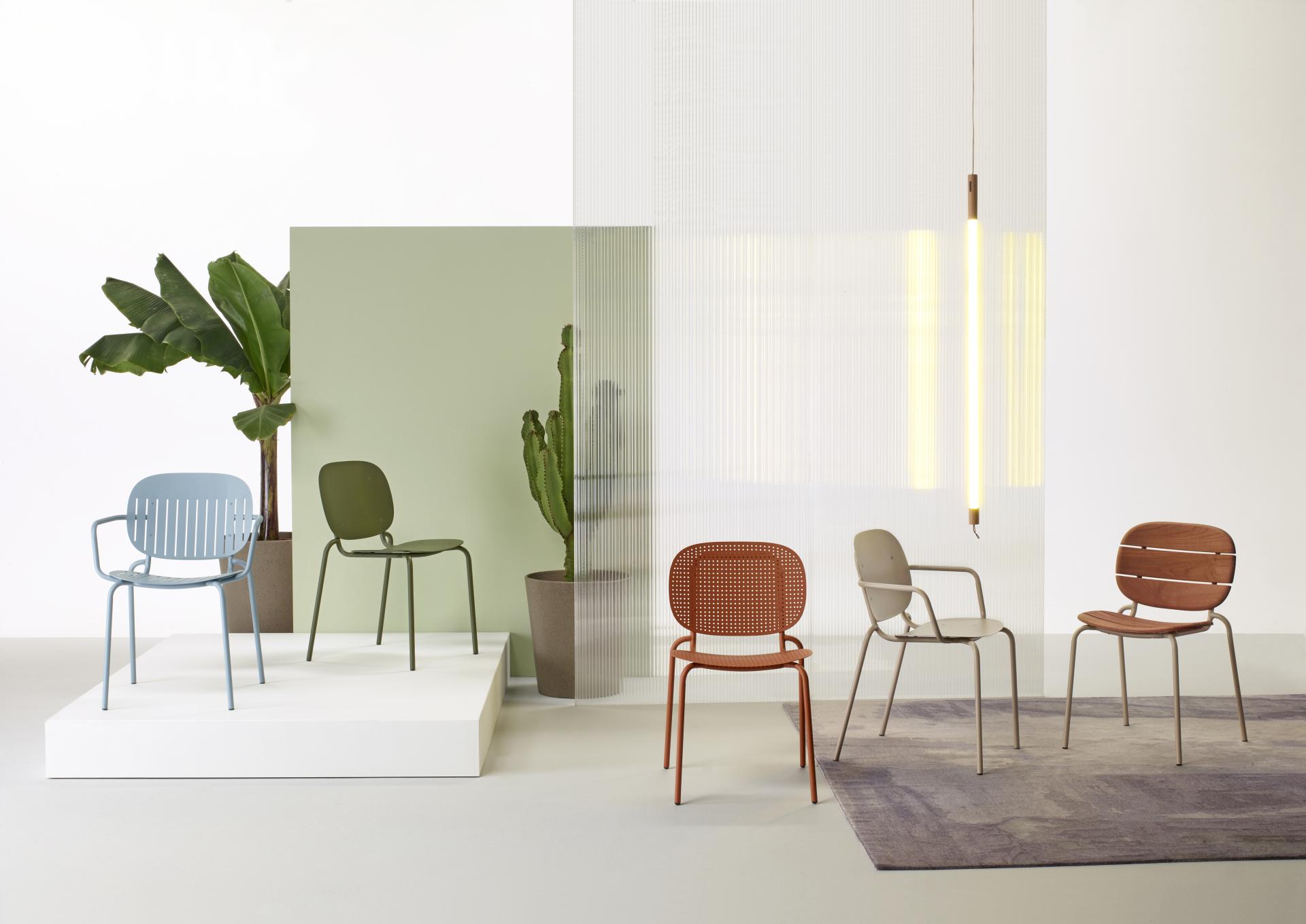 Colorful outdoor chairs set against greenery, showcasing SCAB Design's modern interpretation of the pleasure of being outdoors.