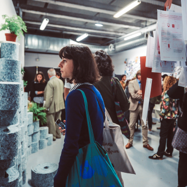 Visitors explore innovative material displays at Paris Design Week, surrounded by creative installations and design concepts.