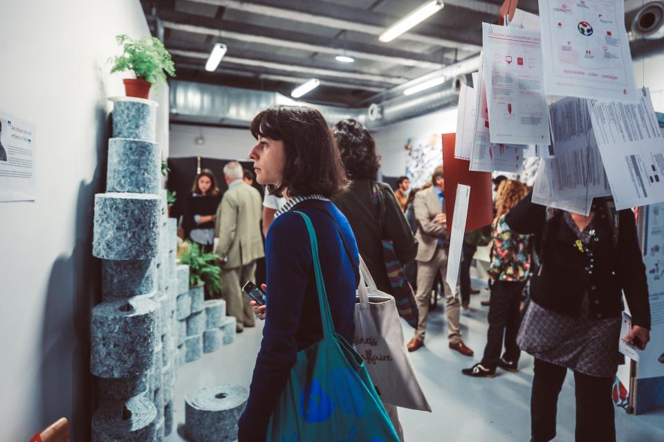 Visitors explore innovative material displays at Paris Design Week, surrounded by creative installations and design concepts.