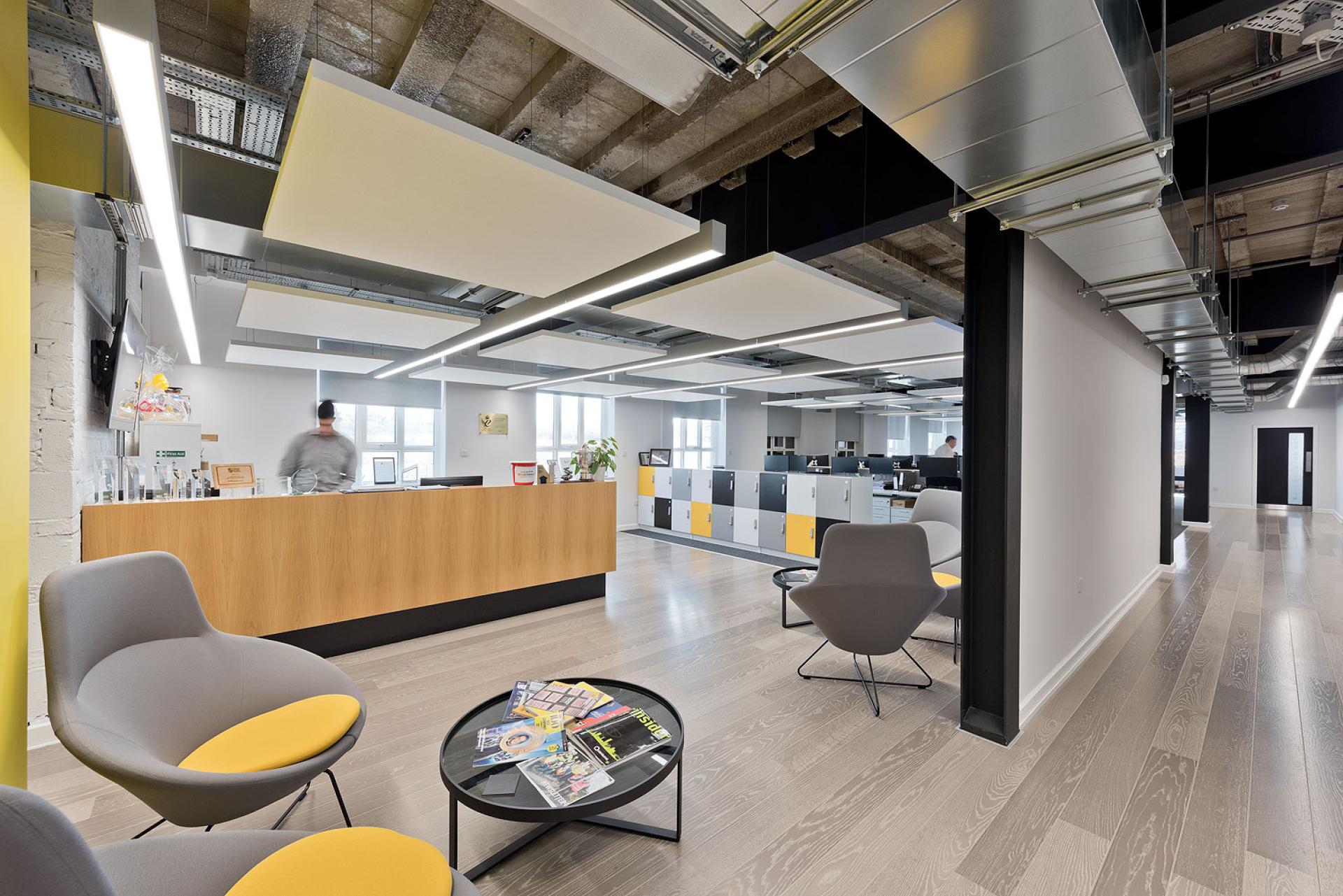 Bright, modern office interior featuring vibrant seating, a reception area, and collaborative workspace highlighting sustainable design principles.