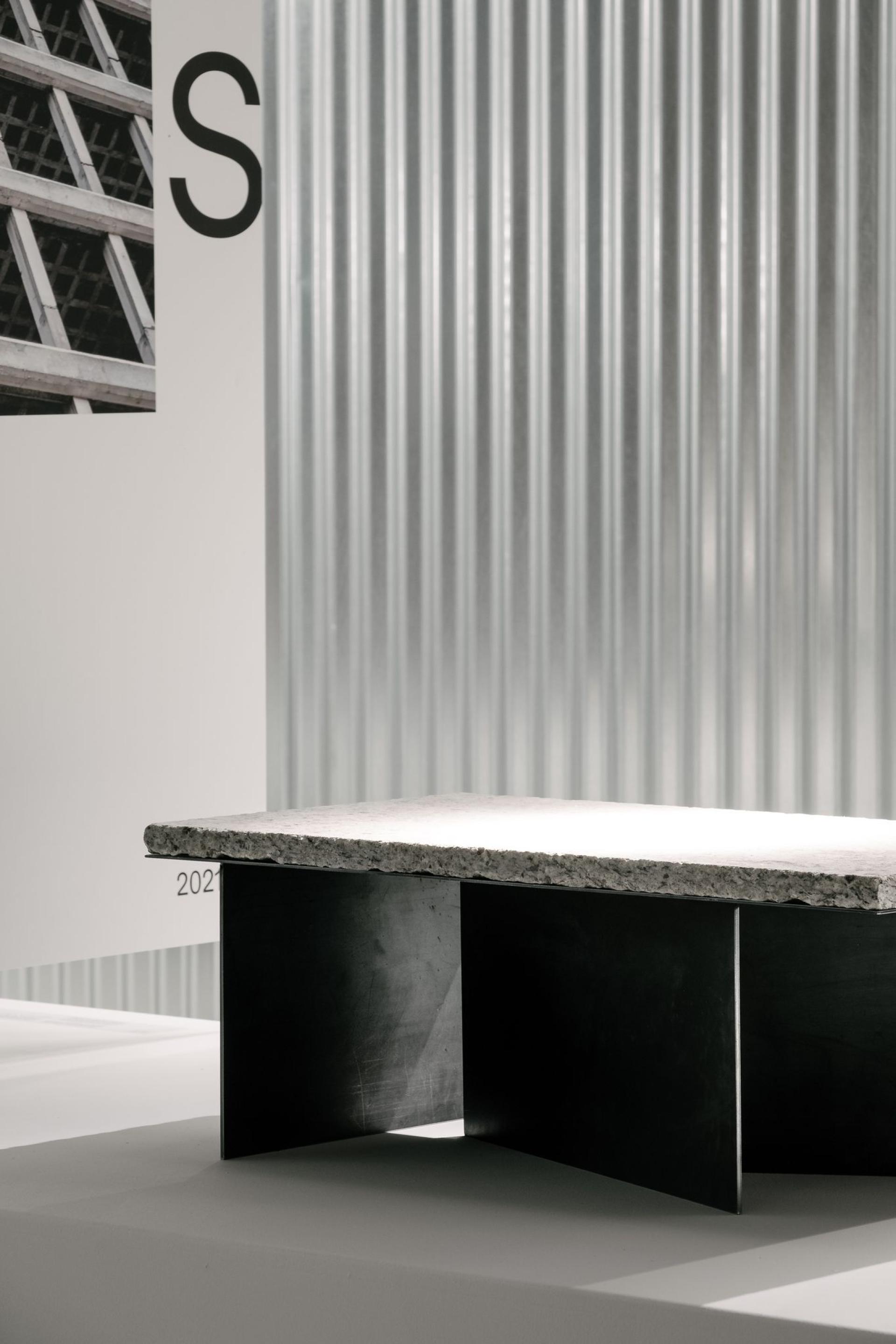 Stylish concrete and metal coffee table displayed in a contemporary interior design studio, emphasizing raw refinement and modern aesthetics.