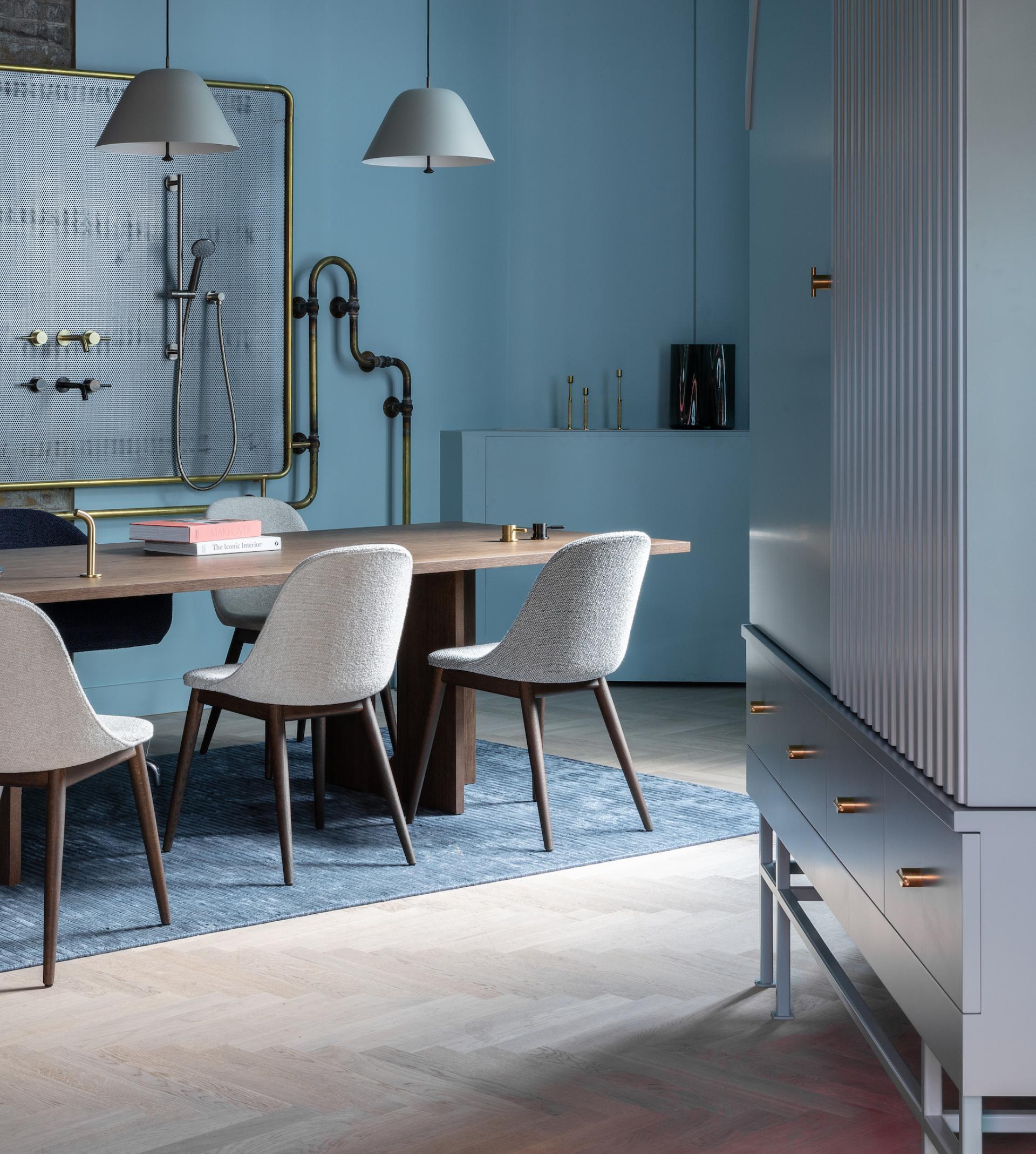 Modern co-working space by Holloway Li featuring a stylish meeting room with a wooden table and designer chairs.