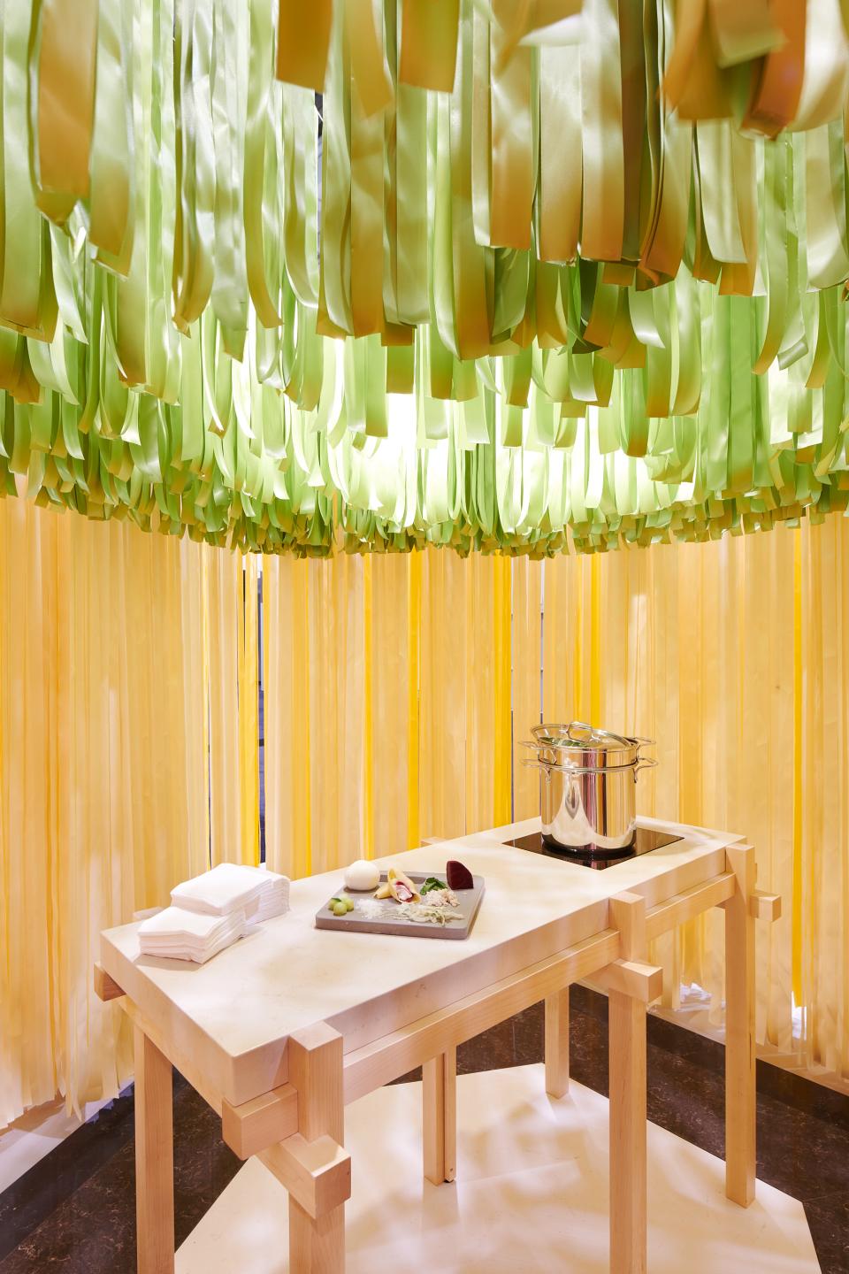 Design-focused dining setup featuring a Caesarstone table, surrounded by vibrant, ribbon-like decor by Marije Vogelzang, highlighting food and design connection.