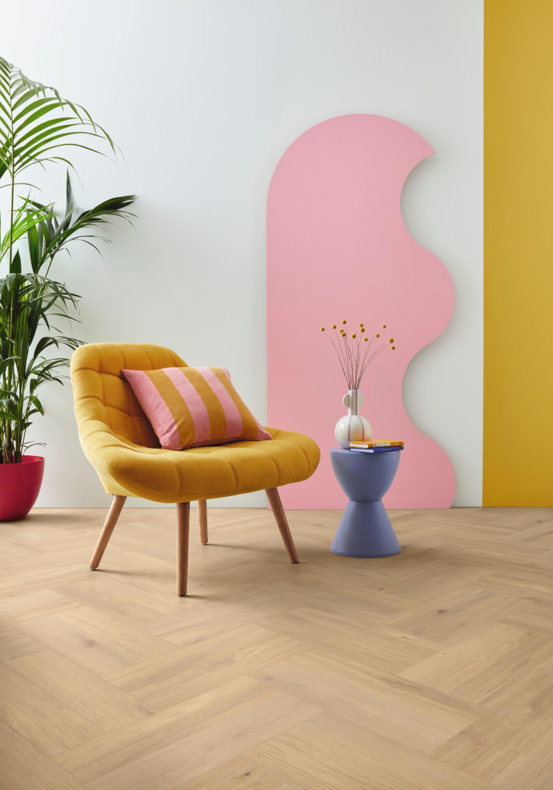 Stylish living space featuring classic oak herringbone flooring, bright yellow chair, vibrant decor, and modern accents.