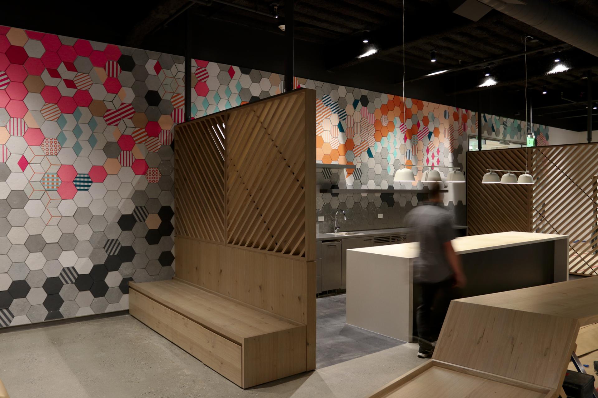 Colorful hexagonal tile wall design in a modern workspace, showcasing the creative collaboration of Dear Human's Jasna Sokolovic and Noel O’Connell.