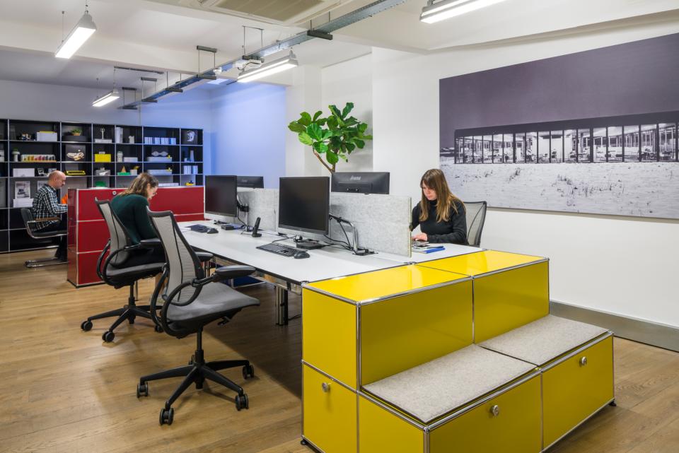 Modern office interior of USM's Clerkenwell showroom featuring modular furniture, creative workspaces, and a collaborative atmosphere.