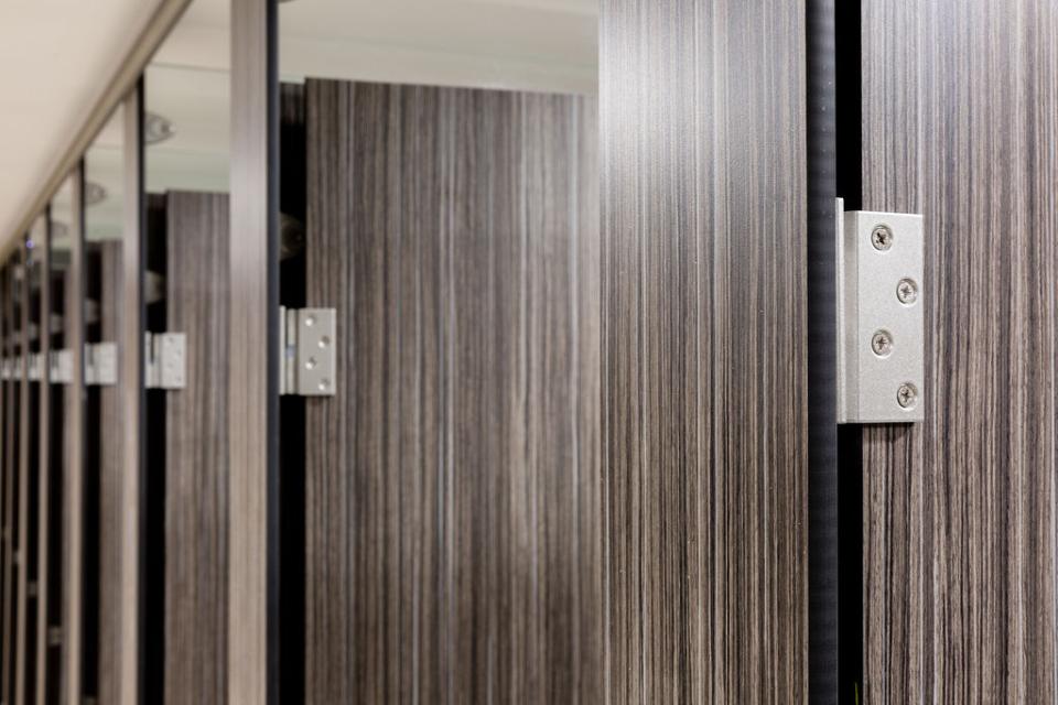 Modern wooden washroom partitions with sleek hardware at Liverpool Street Station, reflecting recent transformation efforts.