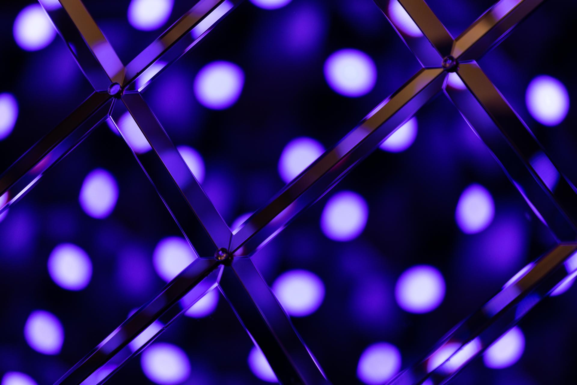 Colorful purple bokeh lighting effect behind a geometric metallic structure, enhancing the ambiance of New Century venue.