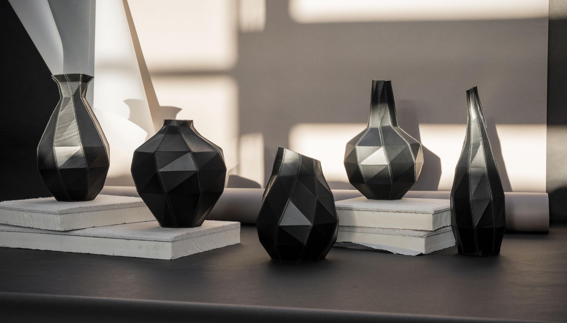 A collection of modern black vases showcasing geometric designs, displayed at the Future Icons Selects exhibition in London.