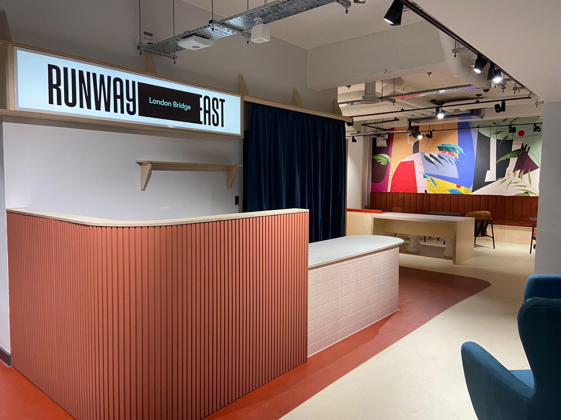 Brightly designed interior of Runway East in London Bridge, featuring artistic murals and modern furnishings promoting creativity and community.