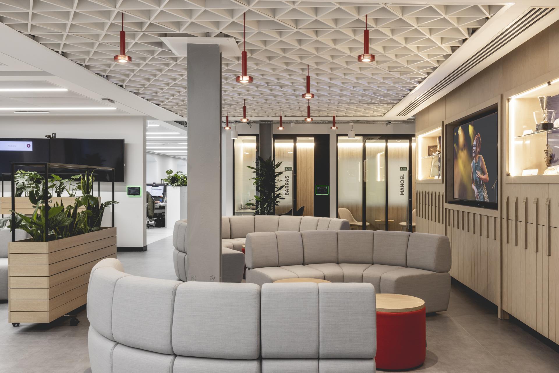 Modern office interior featuring flexible seating, greenery, and artistic lighting reflecting Ekho Studio's music-inspired design for PRS for Music.