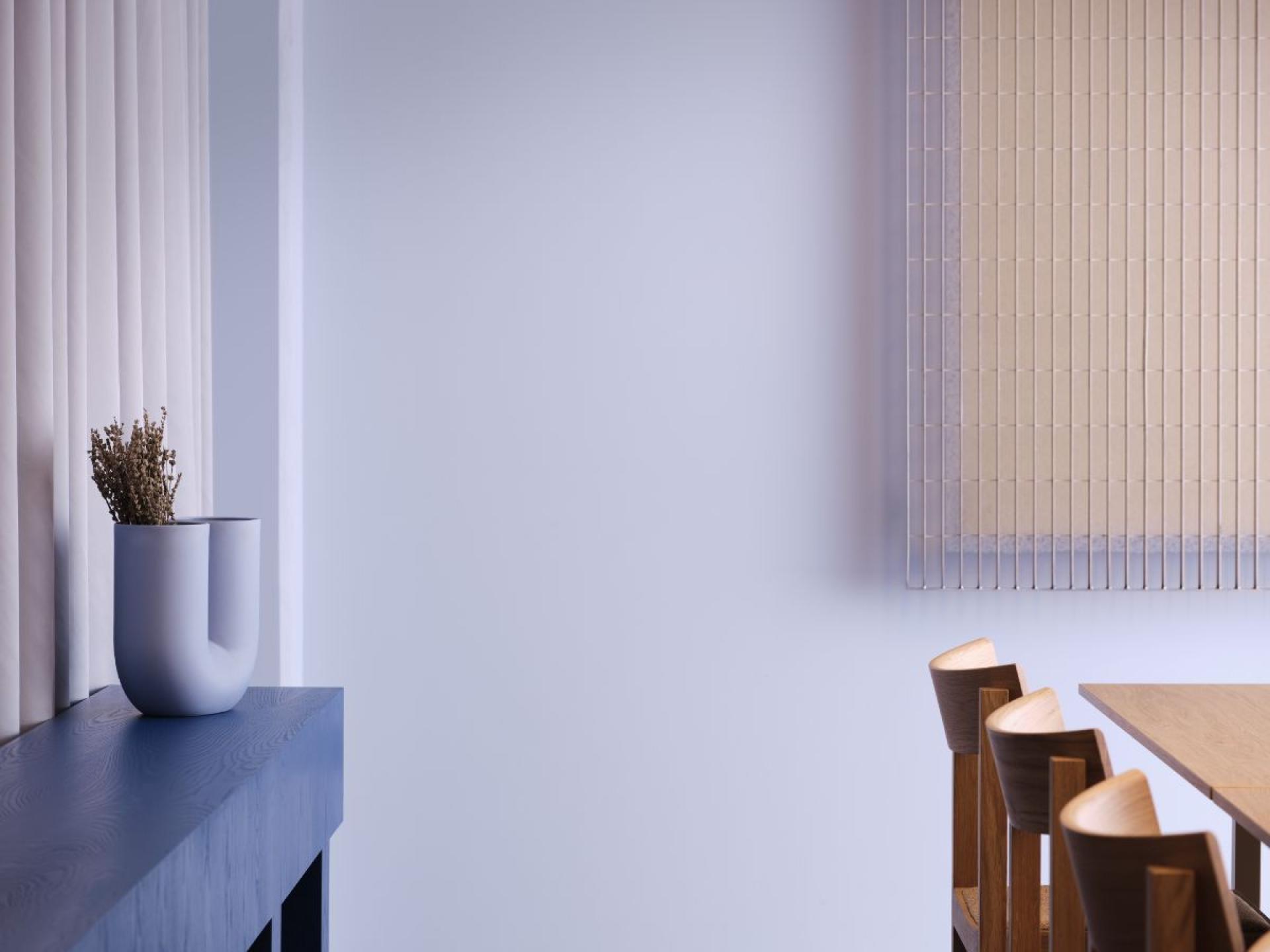 Modern workspace interior featuring a sleek wooden table, elegant chairs, and minimalistic decor for flexible office environments.