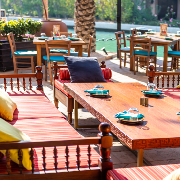 Outdoor seating area of Anar restaurant featuring Persian-inspired decor and vibrant textiles in Souk Madinat Jumeirah, Dubai.