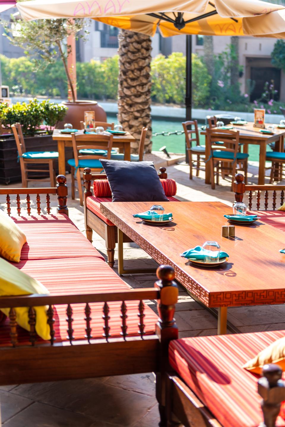 Outdoor seating area of Anar restaurant featuring Persian-inspired decor and vibrant textiles in Souk Madinat Jumeirah, Dubai.