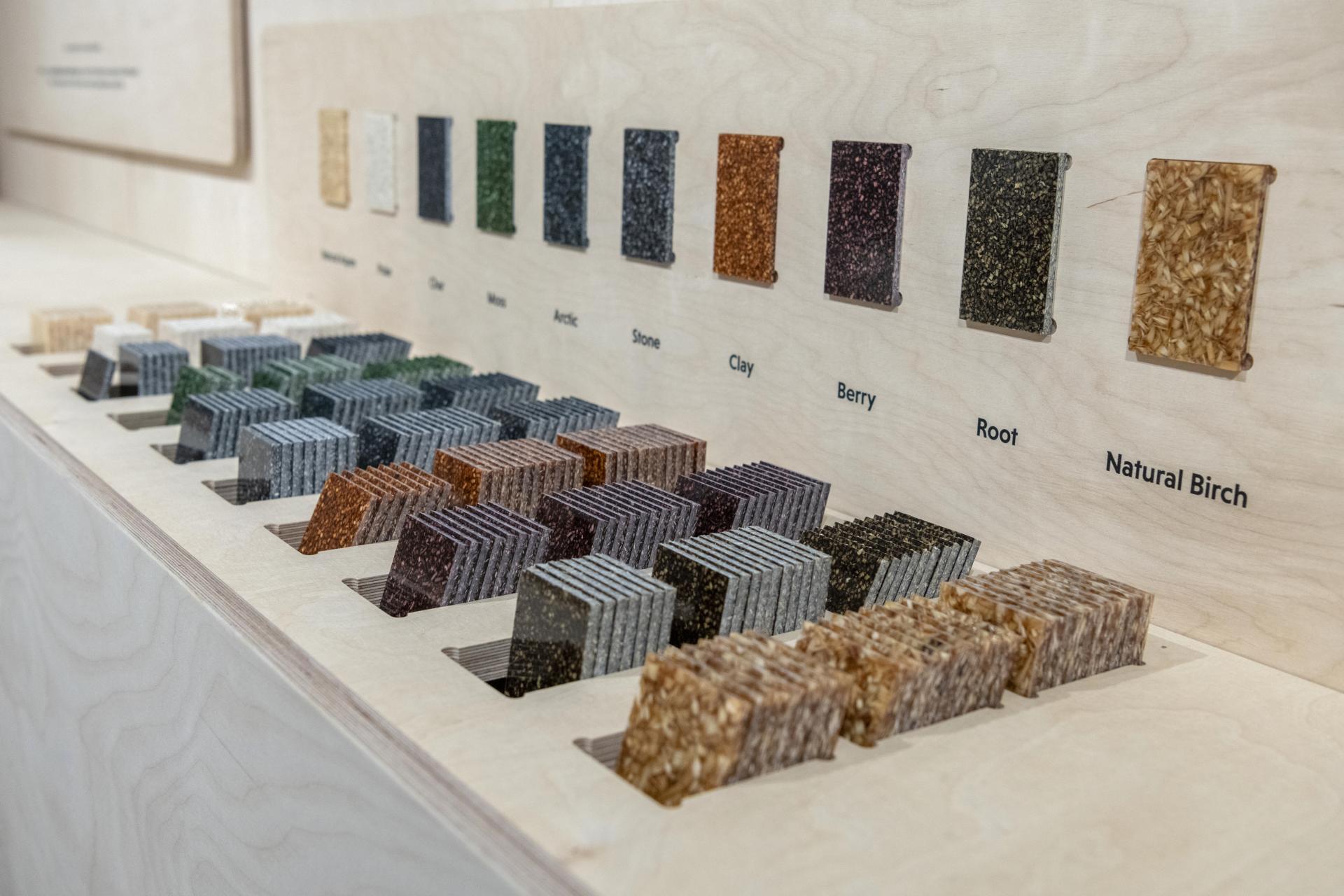 Colorful samples of Woodio® waterproof wood composite materials displayed on a wooden surface for sustainable washroom design.