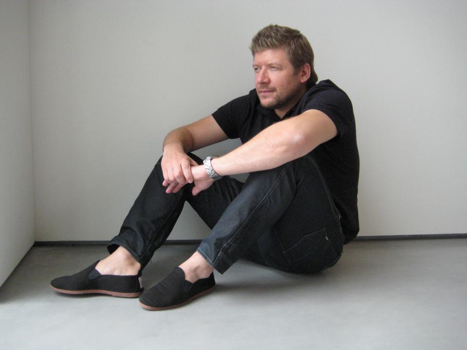 Designer David Fox seated contemplatively in a minimalist space, exploring emerging design trends and material aesthetics.