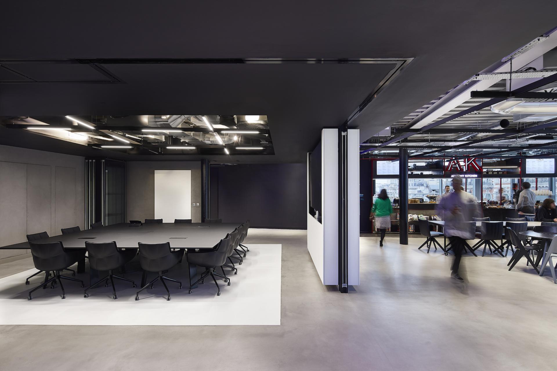 Modern office interior of Sports Direct International featuring a large meeting table and dining area designed by PENSON.