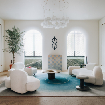 Modern living room featuring Mathieu Lehanneur's furniture, a unique chandelier, and elegant design elements.