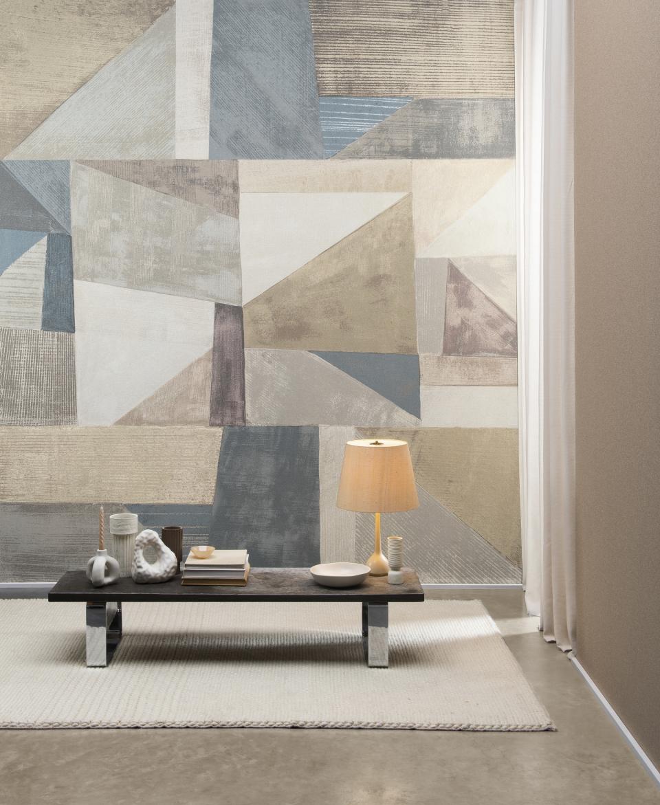 Stylish interior featuring Omexo's geometric wallcovering design with a minimalistic coffee table and warm lamp.