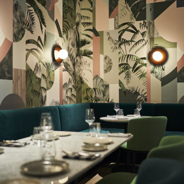 Vibrant restaurant interior featuring unique wallpaper designs from Bespoke Atelier, showcasing modern decor and stylish lighting.
