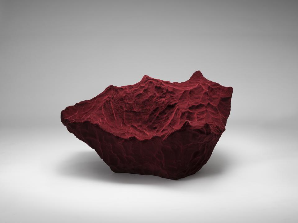 Sculptural red furniture piece resembling a rock, showcasing contemporary design within the Salon Art + Design exhibition.
