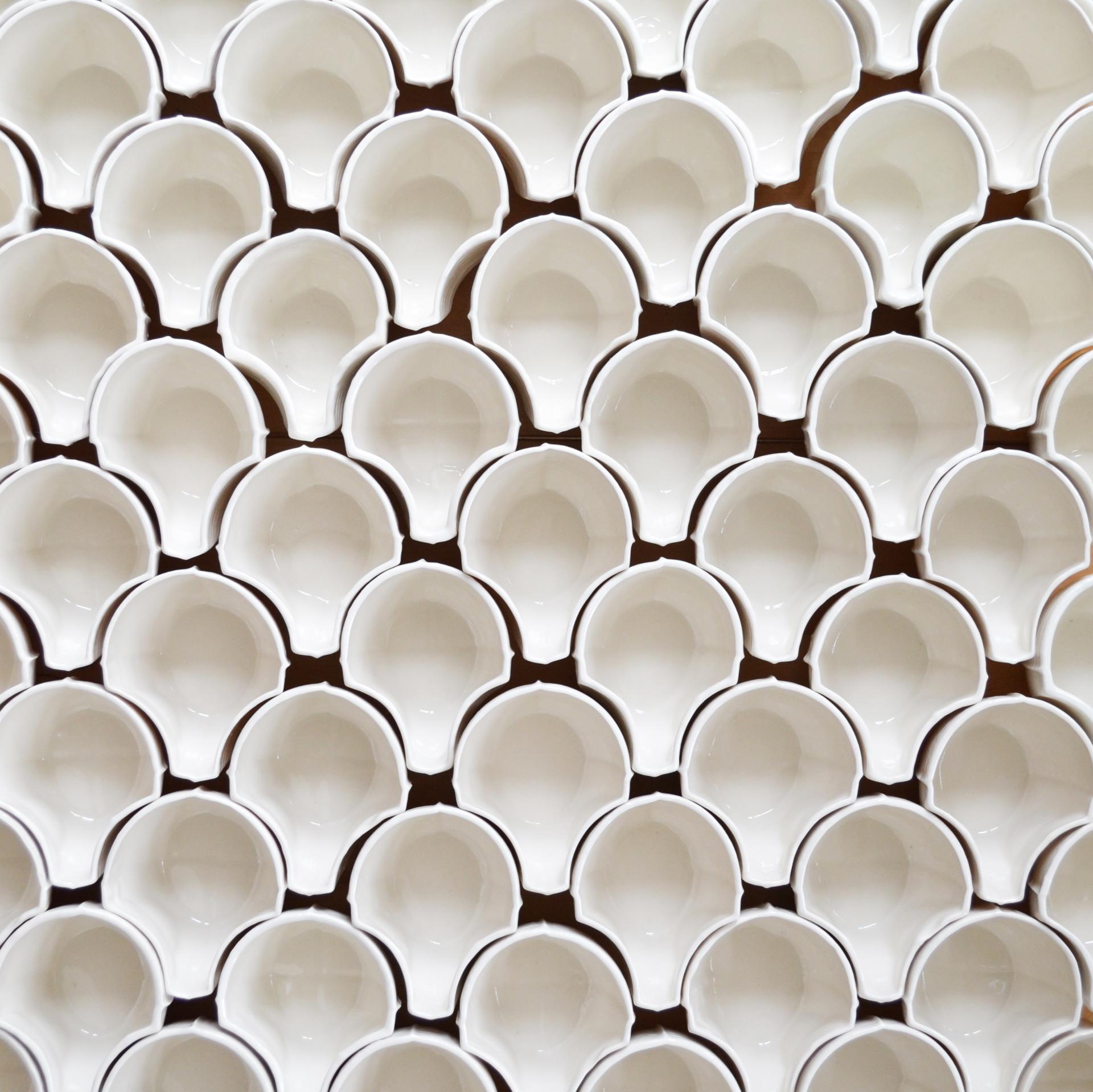 Ceramic fragments arranged in a grid pattern, showcasing the artistry and versatility of ceramics in contemporary architecture.