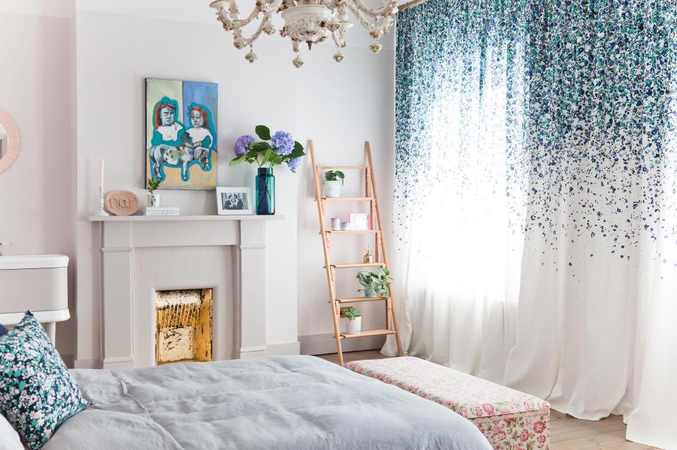 Brightly decorated bedroom featuring colorful artwork, floral curtains, and elegant decor, showcasing the unique design by 2LG Studio.