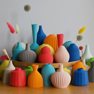 Colorful ceramic vases with unique textures displayed on a wooden tray at the Future Icons Selects exhibition.