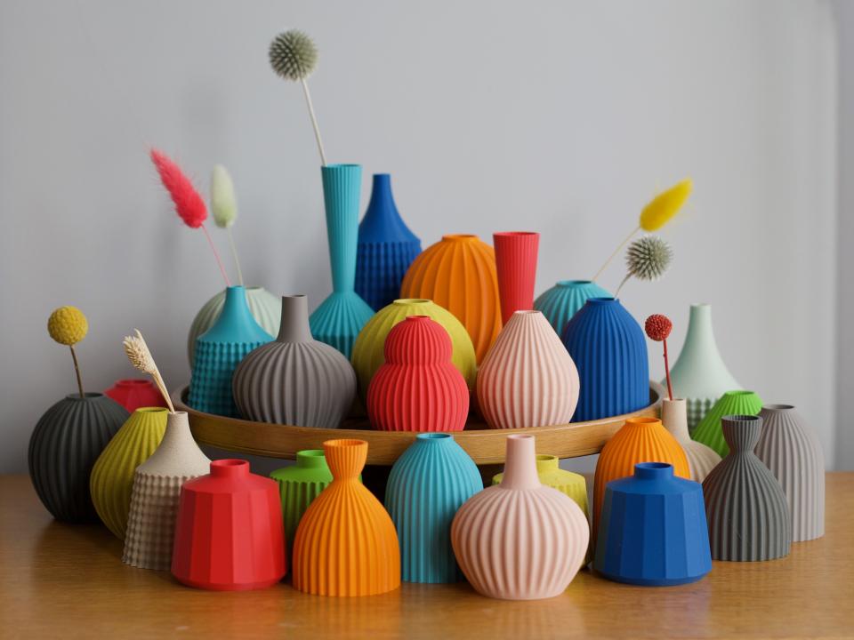 Colorful ceramic vases with unique textures displayed on a wooden tray at the Future Icons Selects exhibition.